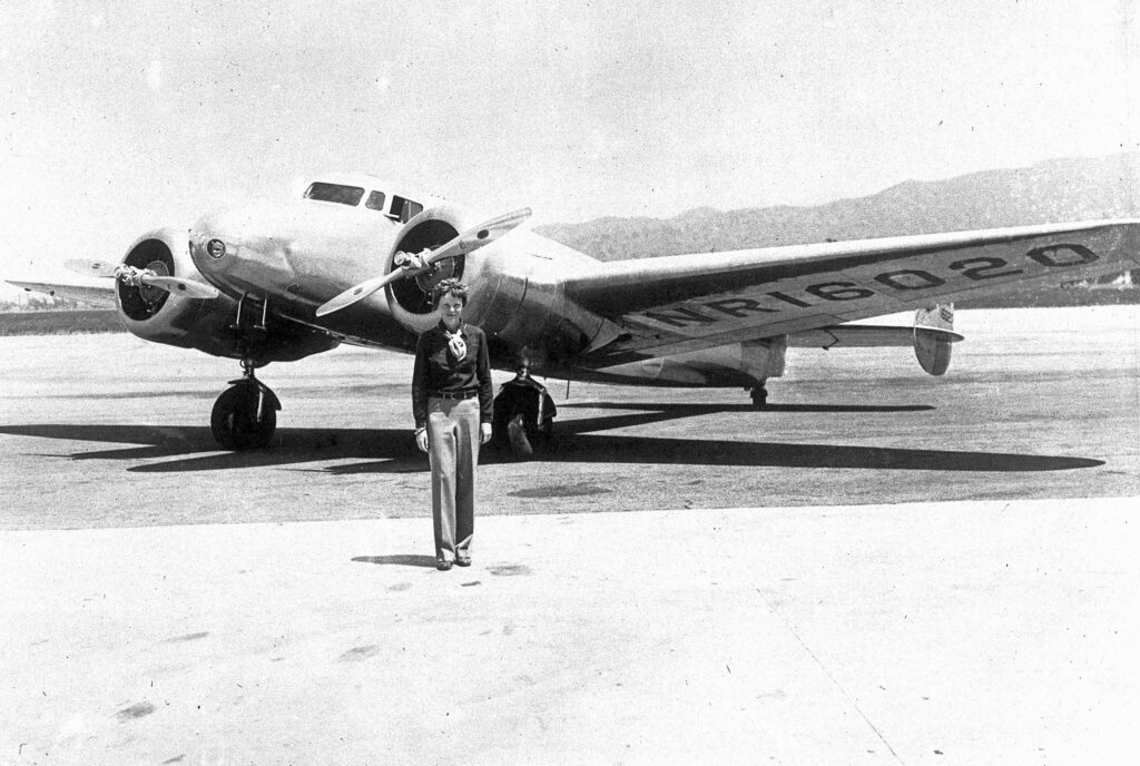 Amelia Earhart poseert voor een vliegtuig