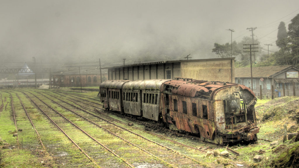 Kunnen schimmels mensen bedreigen? Verlaten en overgroeide treinstellen in apocalyptisch landschap.