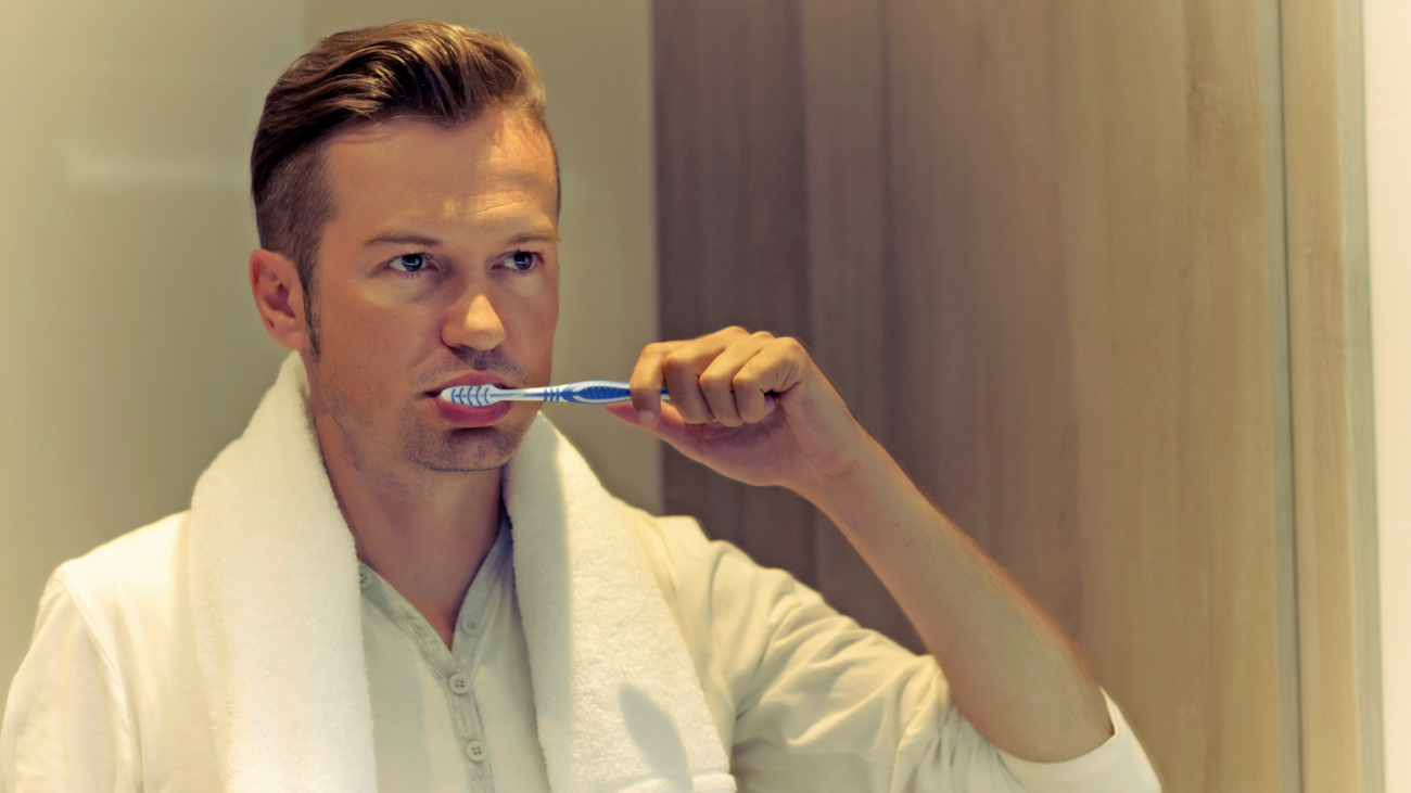Man is bezig met het poetsen van zijn tanden