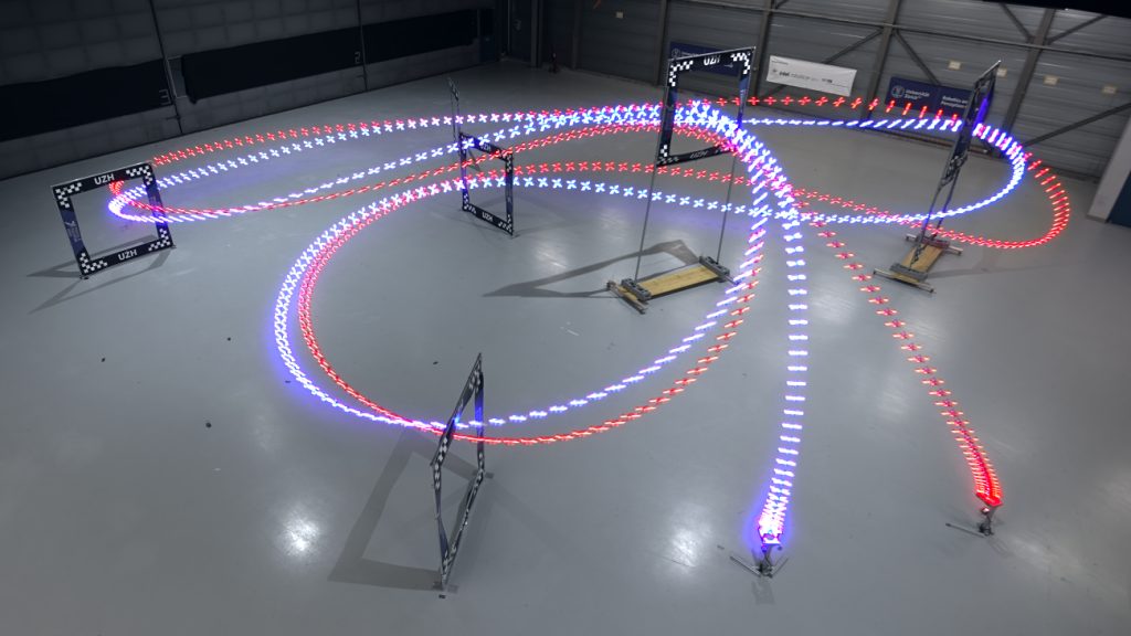 Twee lichtsporen die de route van twee racende drones laat zien. AI wint van professionele droneracer.