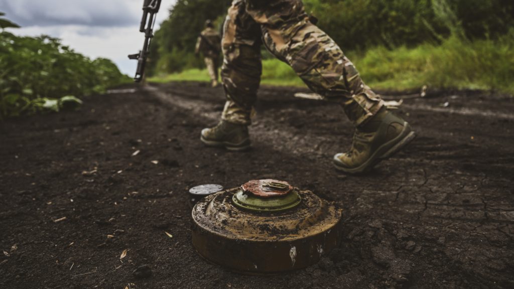 Een landmijn in Oerkaïne, een soldaat loopt er langs