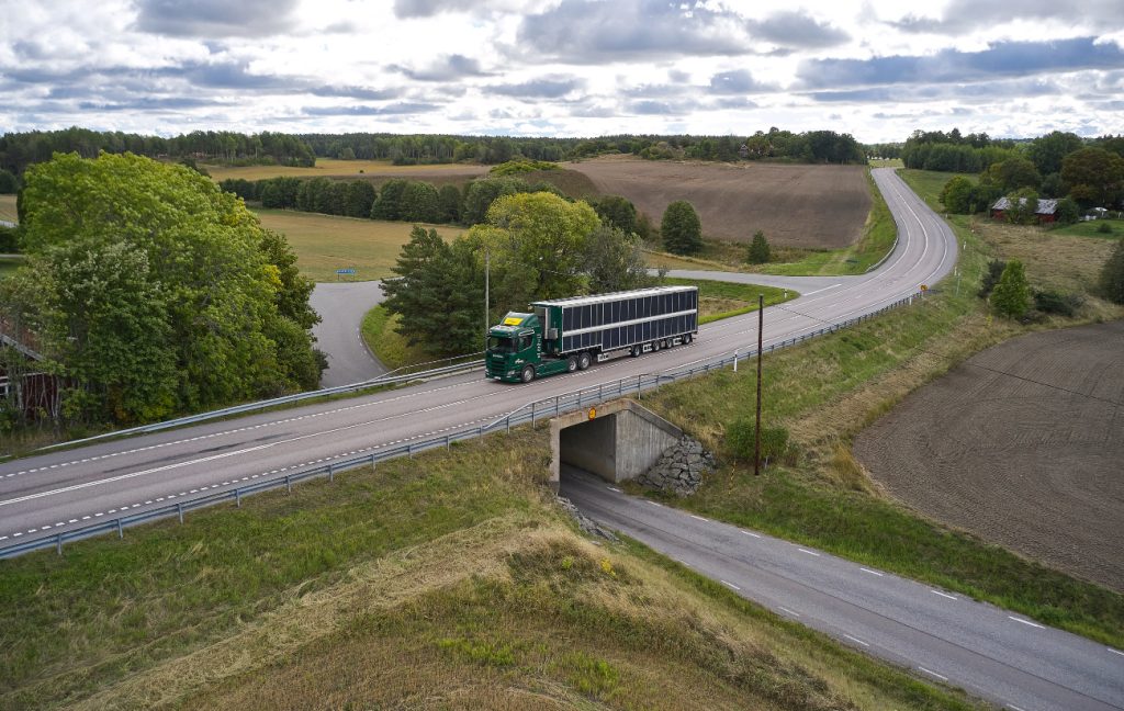 Groene Scania vrachtwagen met zonnepanelen rijdt over de openbare weg