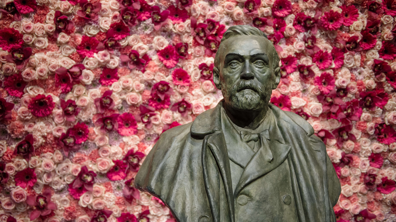 Beeld van Alfred Nobel voor een achtergrond met roze bloemen