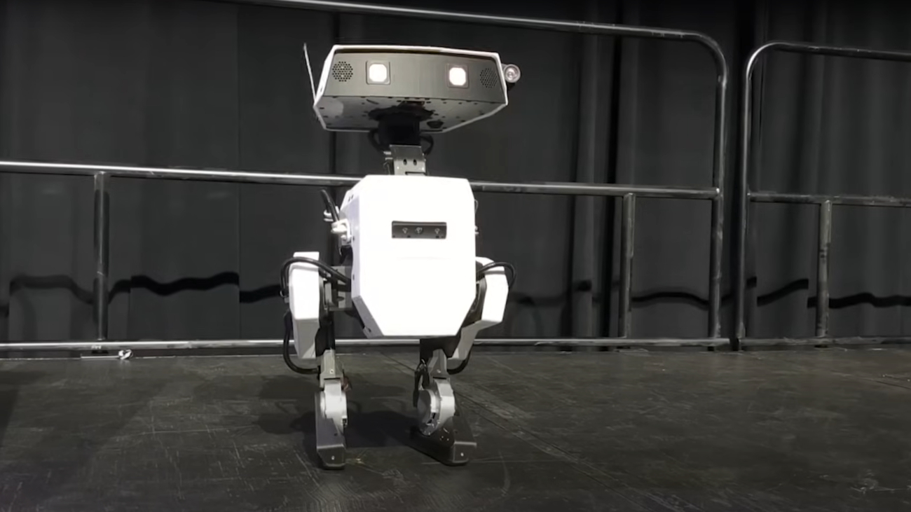 Schattige Disney-robot, met klein vierkant lichaam, kleine benen, en een hoofd met twee antennes.
