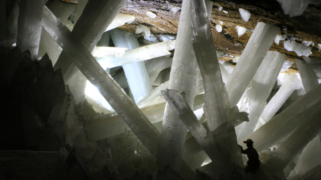 Een man verkent de Cave of Crystals. Door die man zie je goed hoe groot de kristallen zijn.