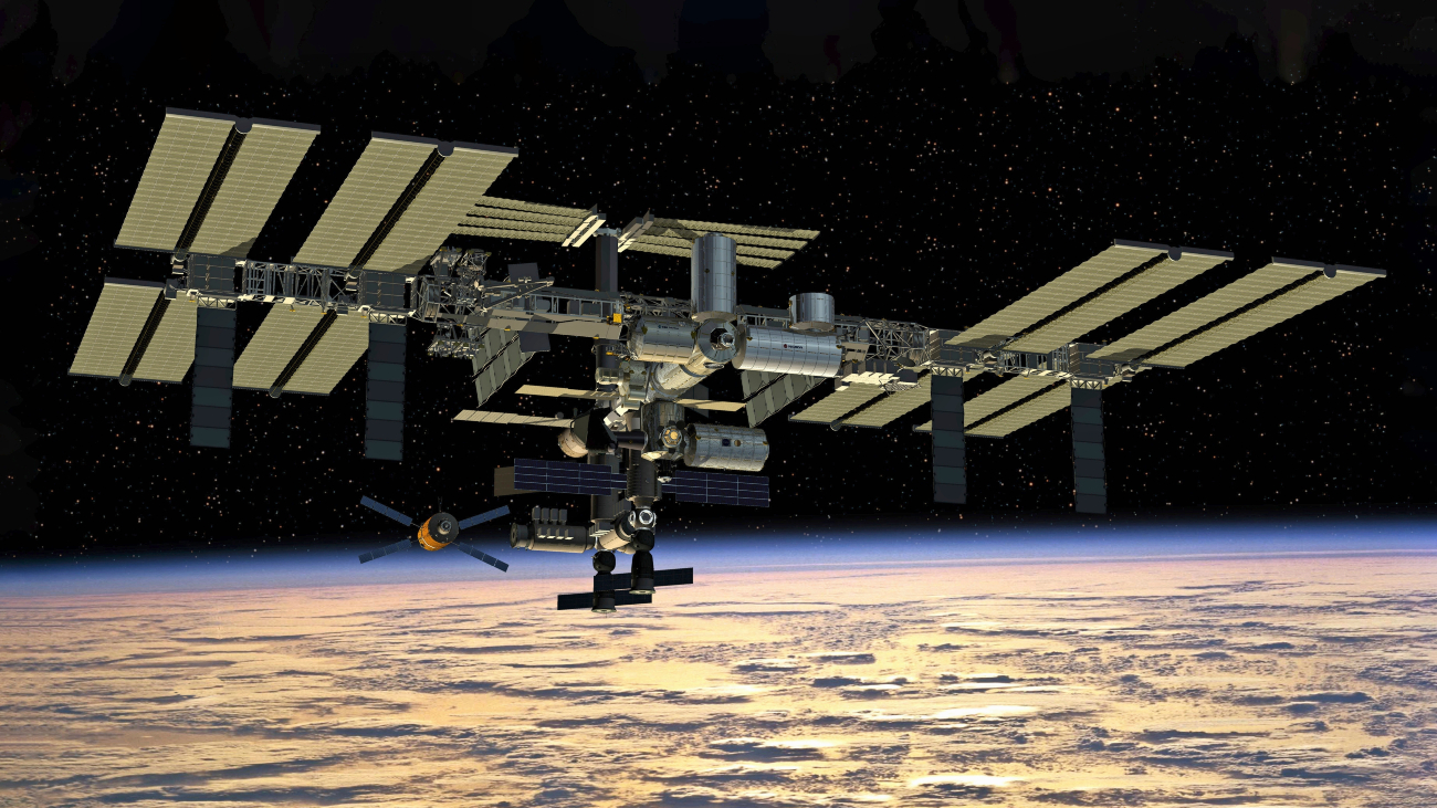 ISS in de ruimte met eronder een deel van de aarde in beeld