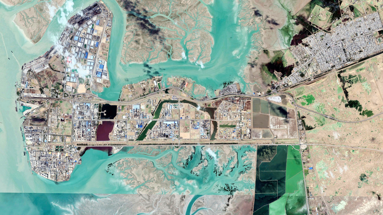 Satellietfoto van enorm petrochemisch complex in Iran, met veel azuurblauw water wat erg aantrekkelijk lijkt maar erg gevaarlijk is