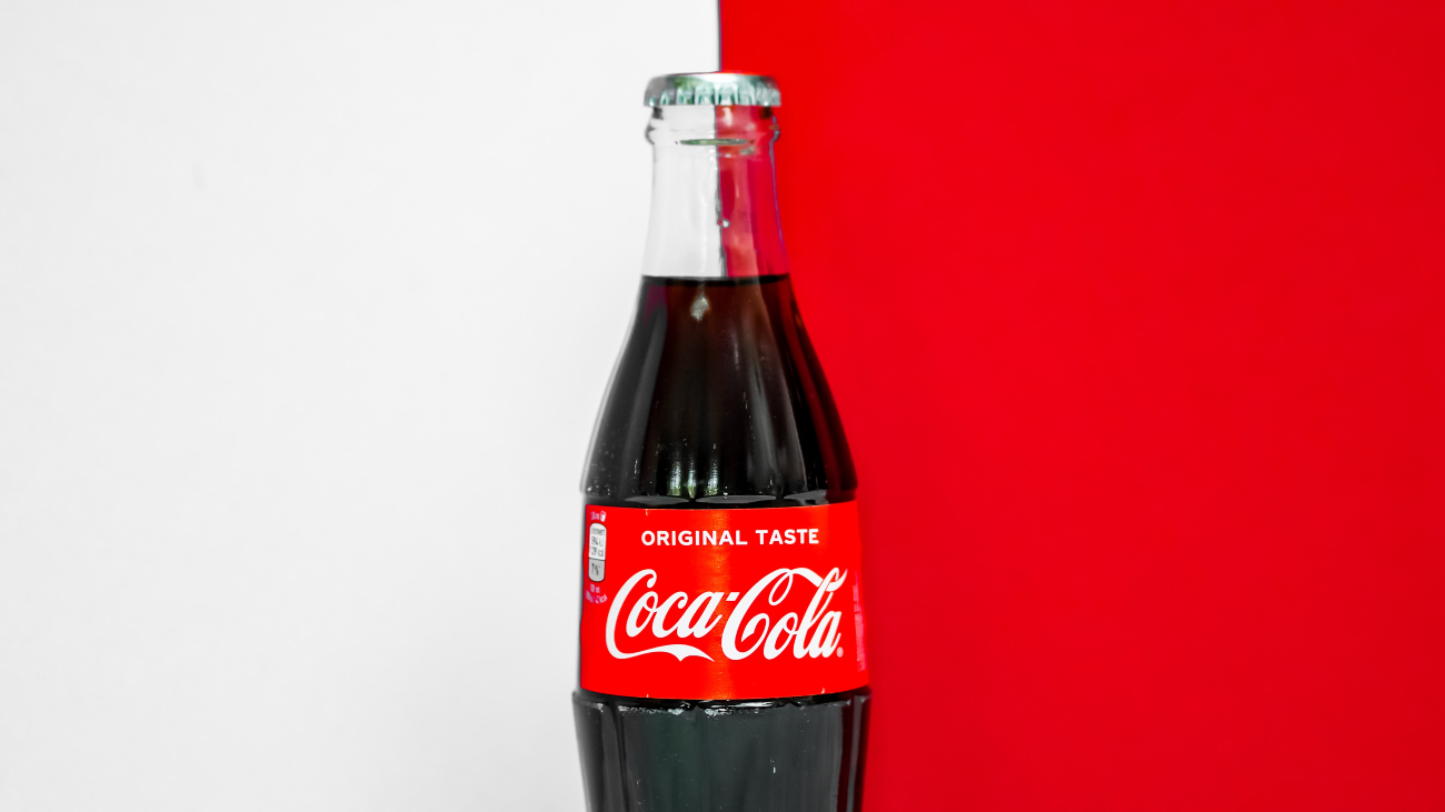 Glazen Coca-Cola-fles op een achtergrond door voor de helft wit en de andere helft rood is