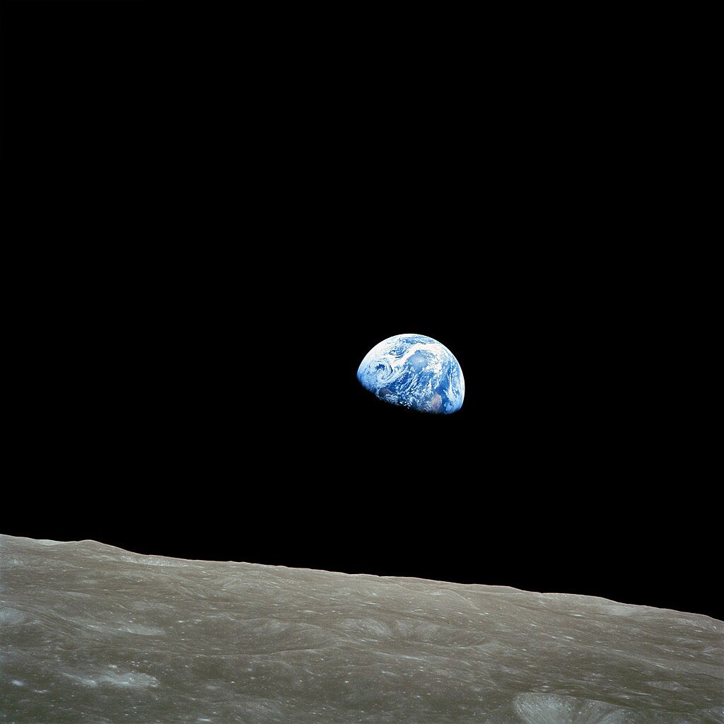 De beroemde 'Earthrise' foto, gemaakt door Bill Anders. Op de voorgrond het maanoppervlak, op de achtergrond de halve aarde. 
