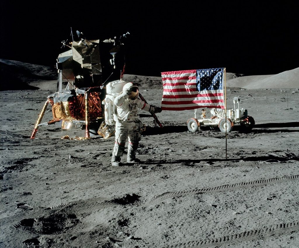 Gene Cernan salueert de Amerikaanse vlag op de maan, hij staat naast de Apollo-lander en de Lunar Roving Vehicle.