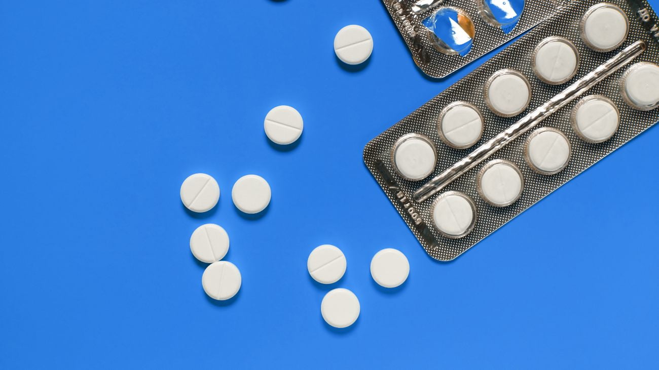 Witte tabletten aspirine op een blauwe achtergrond