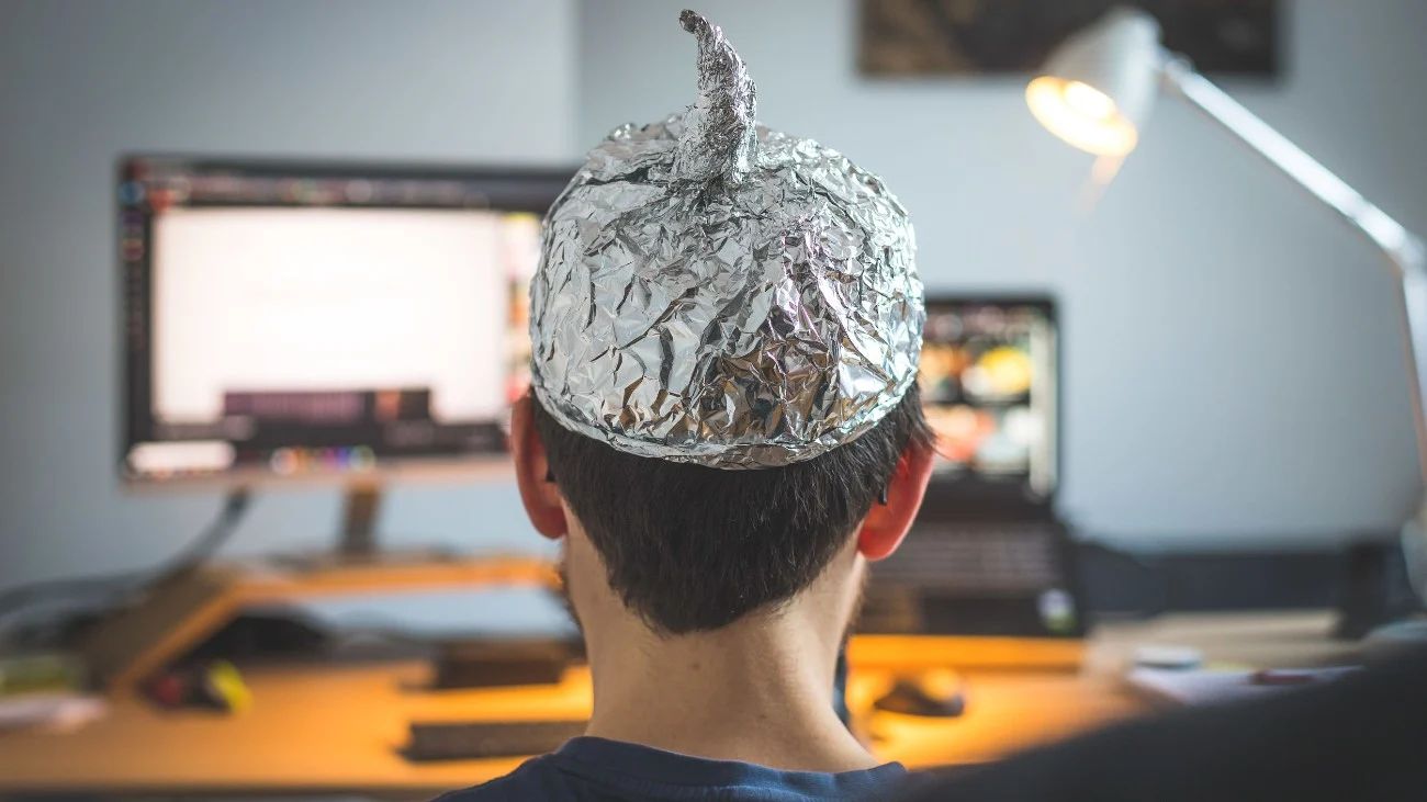 Man die in complottheorie gelooft draag een aluminium hoedje