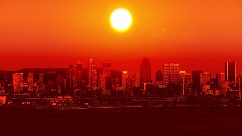 Skyline met rode lucht en zon, lijkt op een hittegolf. De gevoelstemperatuur stijgt sneller dan de daadwerkelijke temperatuur.