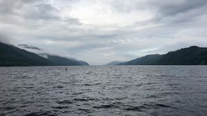 Foto van Loch Ness met in de verte iets wat lijkt op het monster