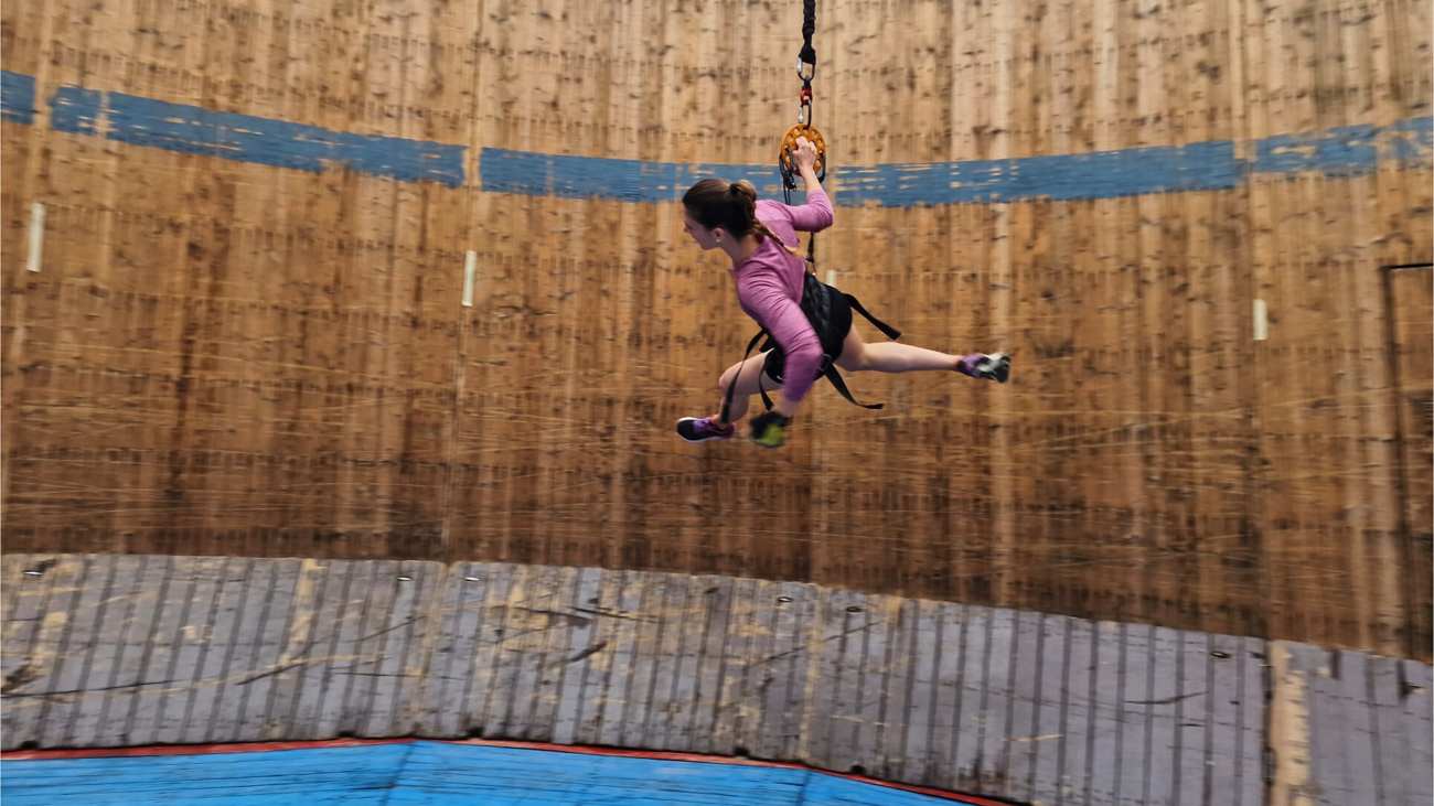 vrouw rent rondjes op de muur des doods terwijl ze een koord omheeft dat maanzwaartekracht simuleert.