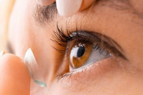 Close-up van iemand die contactlens indoet.
