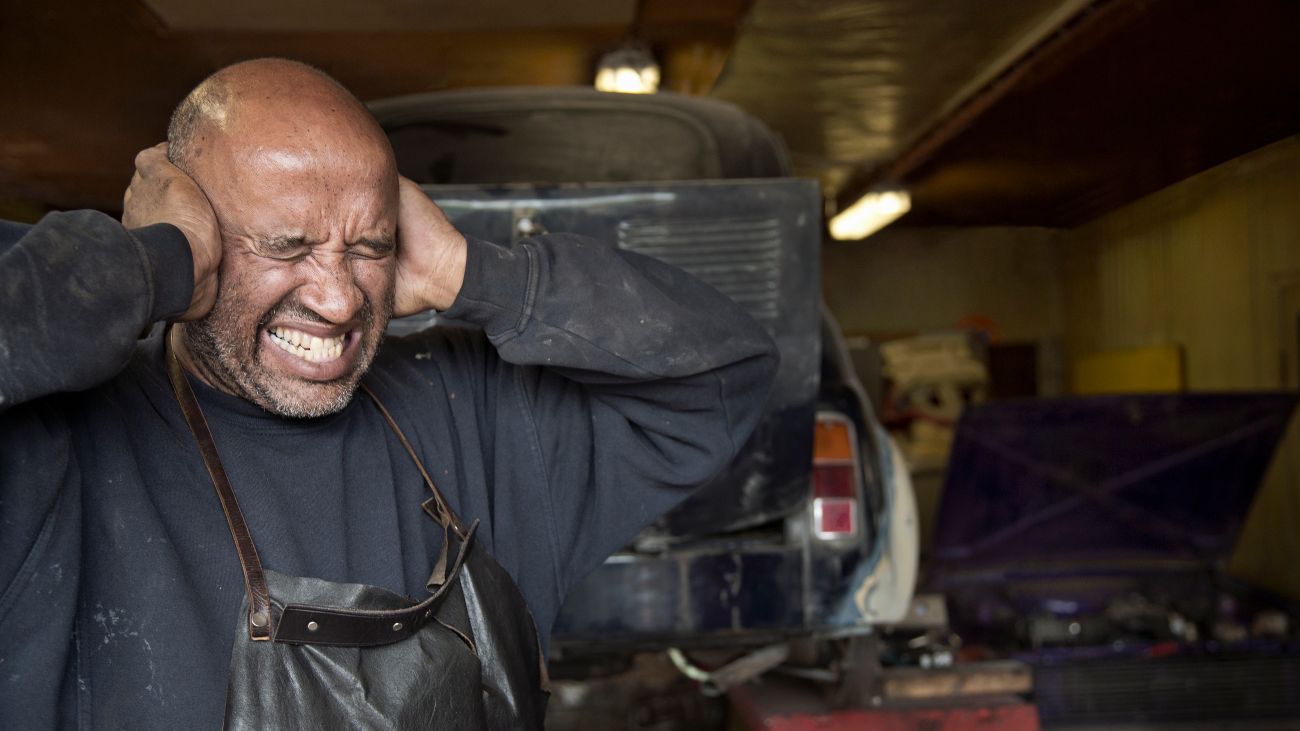 Man bedekt oren vanwege hard geluid