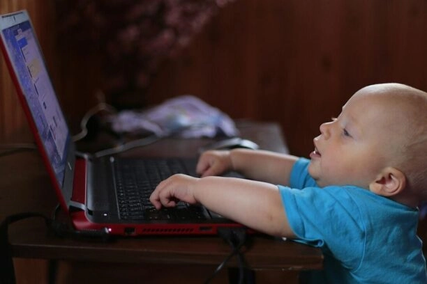 jong kind achter beeldscherm van een laptop