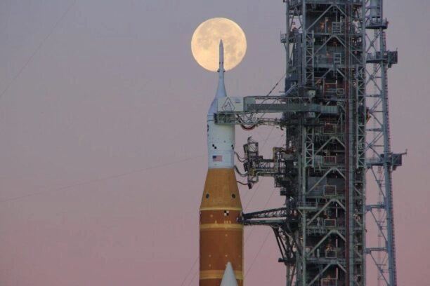Raket voor Artemis II met volle maan op de achtergrond