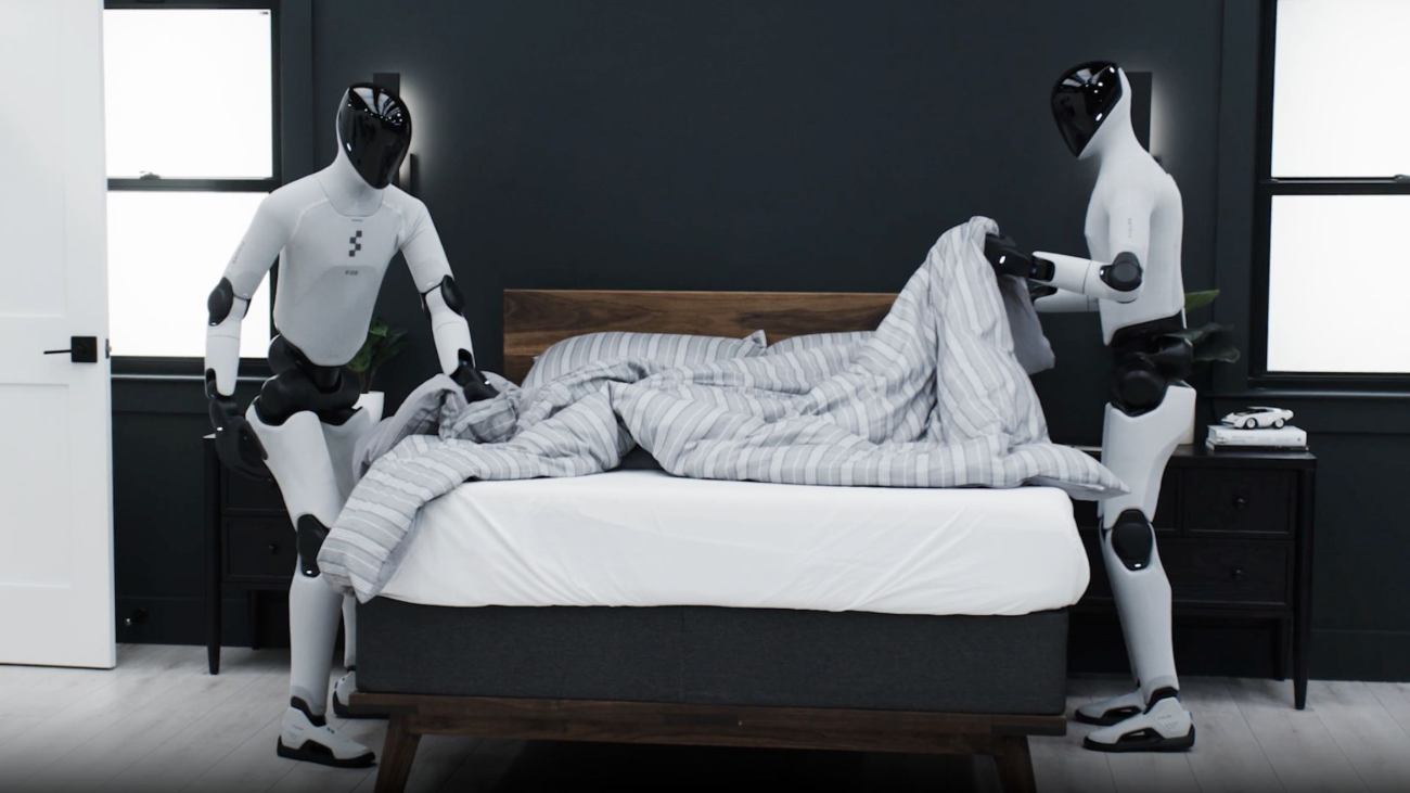 twee humanoïde robots maken een bed op