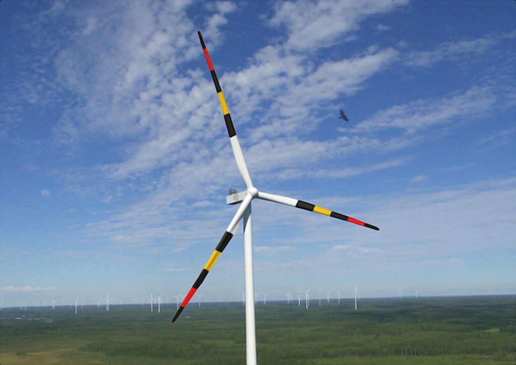 Windturbine waarvan de wieken zwart-rood-geel gestreept zijn