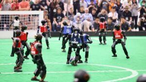 twee robotelftallen voetballen tijdens de RoboCup