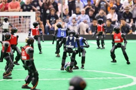 twee robotelftallen voetballen tijdens de RoboCup