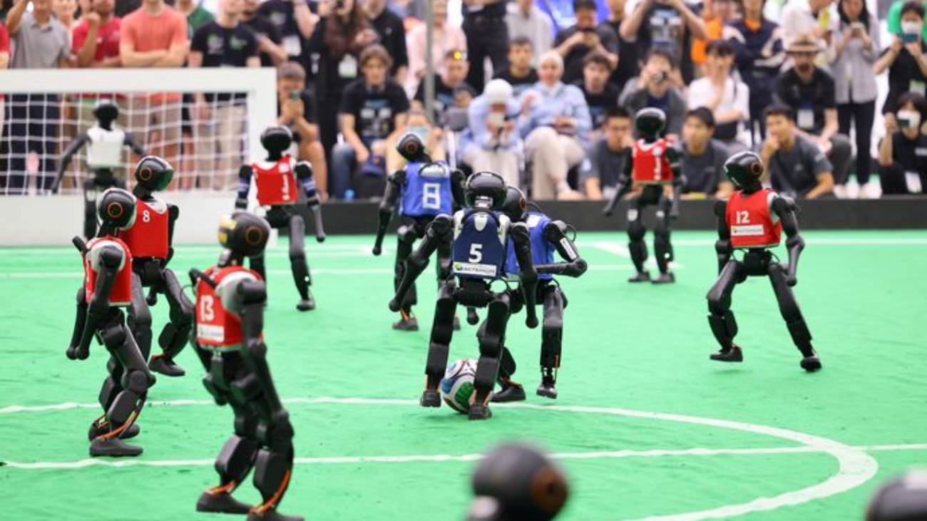 twee robotelftallen voetballen tijdens de RoboCup