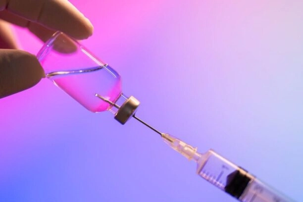 injectienaald in een potje met peptiden