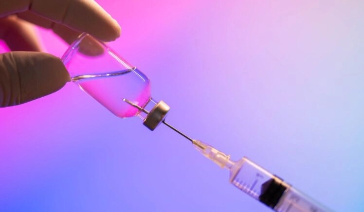 injectienaald in een potje met peptiden