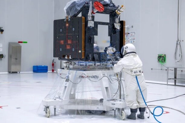 Persoon in beschermend pak tankt de satelliet FLEX met hydrazine