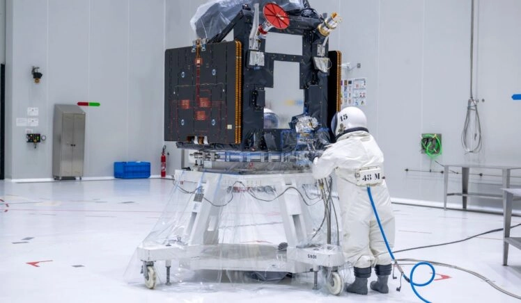 Persoon in beschermend pak tankt de satelliet FLEX met hydrazine