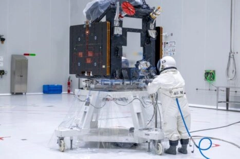 Persoon in beschermend pak tankt de satelliet FLEX met hydrazine