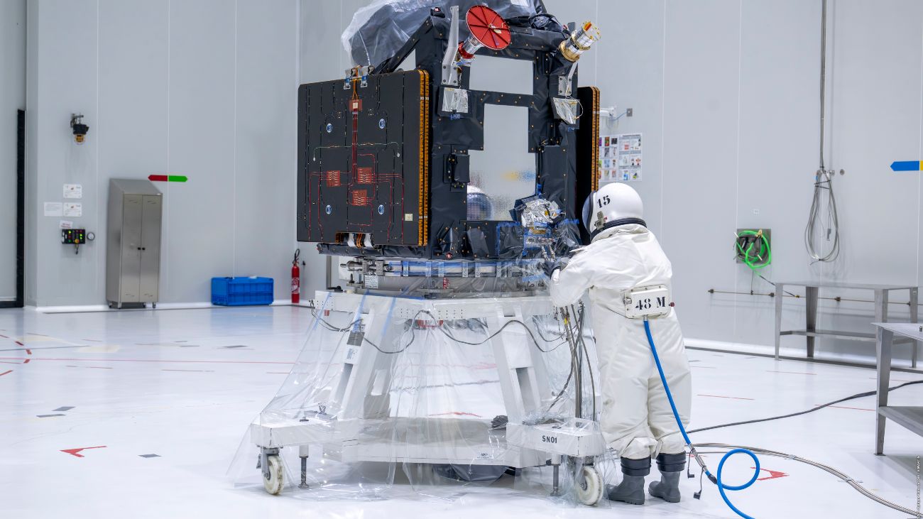 Persoon in beschermend pak tankt de satelliet FLEX met hydrazine